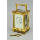 AN EARLY 20TH CENTURY GILT BRASS CARRIAGE CLOCK, the handle, four columns, pediment and foot cast