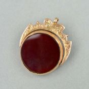 A VICTORIAN 9CT SWIVEL FOB, with scrolling design, set with bloodstone and cornelian in a circular