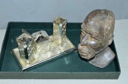 AN EP ON ZINC THREE PIECE CRUET SET AND STAND, together with a soapstone bust of Tribal head,
