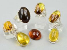 TWO BURMESE AMBER PENDANTS, one of pear shape outline with decorative mount and one an oval
