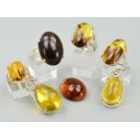 TWO BURMESE AMBER PENDANTS, one of pear shape outline with decorative mount and one an oval