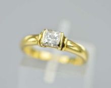 AN 18CT DIAMOND SOLITAIRE RING, featuring a princess cut diamond in a partial rub over setting,