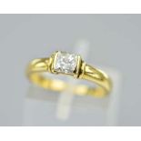 AN 18CT DIAMOND SOLITAIRE RING, featuring a princess cut diamond in a partial rub over setting,