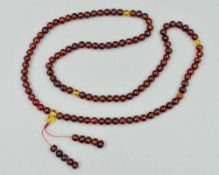 A BURMESE AMBER BEAD NECKLACE, the uniform spherical beads measuring 7mm, approximate length