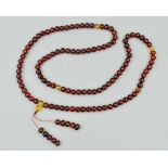 A BURMESE AMBER BEAD NECKLACE, the uniform spherical beads measuring 7mm, approximate length