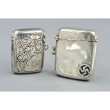 TWO SILVER VESTA CASES, the first with scrolling acanthus leaf decoration and engraved monogram,