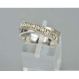 A DIAMOND HALF ETERNITY RING, of crossover design, one line claw set with modern round brilliant cut