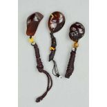 THREE BURMESE AMBER PENDANTS, the first carved to depict fruit, the other two polished amber pieces,