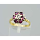 AN 18CT GOLD RUBY AND DIAMOND CLUSTER RING, the central modern round brilliant cut diamond within