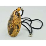 A CARVED BURMESE AMBER PENDANT, carved to depict a money bat with a cord chain, approximate length