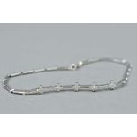 A 9CT DIAMOND BRACELET, with five sets of four diamonds set in flower shapes on a bar chain, with