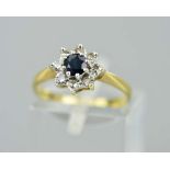 AN 18CT SAPPHIRE AND DIAMOND CLUSTER RING, the central circular sapphire within a single cut diamond