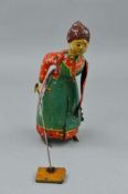 A TINPLATE CLOCKWORK 'BUSY LIZZIE' SWEEPING WOMAN FIGURE, lithographed red dress with white spots