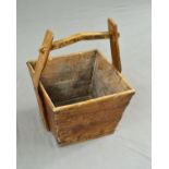 A 19TH CENTURY WOODEN LOG BASKET, of square tapering form, fitted with a pegged handle on shaped