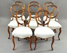 A MATCHED SET OF EIGHT VICTORIAN WALNUT BALLOON BACK DINING CHAIRS, with carved foliate and scroll