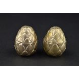 A PAIR OF 20TH CENTURY NOVELTY WHITE METAL PEPPERETTES, of ovoid form, pineapple style bodies,