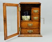 A LATE VICTORIAN OAK SMOKERS CABINET, glazed door enclosing an arrangement of four drawers with