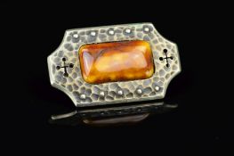 AN ARTS & CRAFTS 'RUSKIN' STYLE BROOCH, the golden rectangular ceramic cabochon to a hammered