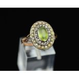 A 19TH CENTURY PERIDOT, DIAMOND AND SEED PEARL RING, an oval cluster measuring approximately 17.