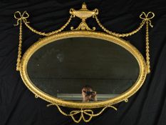 A 19TH CENTURY NEO-CLASSICAL STYLE GILT WOOD OVAL OVERMANTEL MIRROR, with twin handled urn surmount,