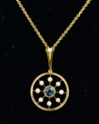 AN EARLY 20TH CENTURY AQUAMARINE AND SEED PEARL PENDANT, centring on a round mixed cut aquamarine