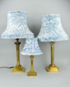 A NEAR PAIR OF EARLY 20TH CENTURY BRASS CORINTHIAN COLUMN TABLE LAMPS, on stepped square bases,