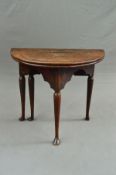 A GEORGE II OAK FOLD OVER COUNTRY TEA TABLE, of Demi Lune shape, on a triangular base with wavy