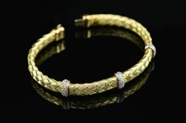 A MODERN DIAMOND SET FLEXIBLE PLAITED DESIGN BANGLE, inlaid with pave diamond set collars, bangle