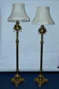 A PAIR OF LATE VICTORIAN BRASS STANDARD OIL LAMPS, converted to electricity, the reservoirs of