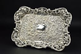 AN EDWARDIAN SILVER DRESSING TABLE TRAY, of shaped rectangular form, pierced border, central blind