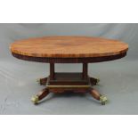 AN EARLY 19TH CENTURY MAHOGANY OVAL CENTRE TABLE, with fluted frieze, four block supports to a