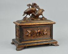 A LATE 19TH CENTURY BLACK FOREST TEA CADDY, or rectangular form, the hinged cover carved with two