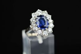 A MODERN LARGE OVAL SAPPHIRE AND DIAMOND CLUSTER RING, sapphire measuring approximately 10.0mm x 8.