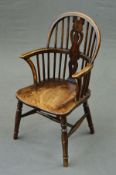 AN EARLY 20TH CENTURY CHILD'S WINDSOR ELBOW CHAIR, in stained ash and beech, pierced vase splat