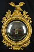 A VICTORIAN GILT WOOD CONVEX WALL MIRROR, surmounted by an eagle with outstretched wings on a