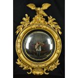 A VICTORIAN GILT WOOD CONVEX WALL MIRROR, surmounted by an eagle with outstretched wings on a