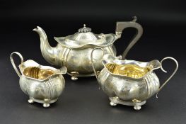 A GEORGE V THREE PIECE SILVER BACHELORS TEASET, of wavy oval outline, engraved foliate