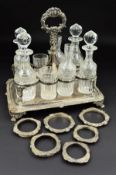 A GEORGE III RECTANGULAR SILVER EIGHT BOTTLE CRUET, foliate cast central handle above eight circular