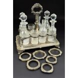 A GEORGE III RECTANGULAR SILVER EIGHT BOTTLE CRUET, foliate cast central handle above eight circular