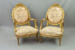 A PAIR OF 19TH CENTURY FRENCH GILT WOOD FAUTEUILS, the oval backs surmounted by floral and musical