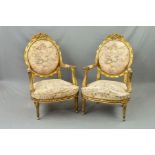 A PAIR OF 19TH CENTURY FRENCH GILT WOOD FAUTEUILS, the oval backs surmounted by floral and musical