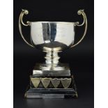 AN ELIZABETH II SILVER TWIN HANDLED TROPHY CUP, of circular form, short knopped pedestal, square