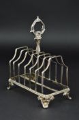 A VICTORIAN SILVER SEVEN BAR TOAST RACK, of rectangular form, foliate cast handle, scroll feet,