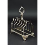 A VICTORIAN SILVER SEVEN BAR TOAST RACK, of rectangular form, foliate cast handle, scroll feet,