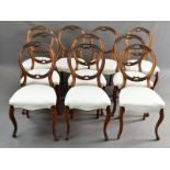 A MATCHED SET OF TEN VICTORIAN WALNUT BALLOON BACK DINING CHAIRS, with carved foliate and scroll