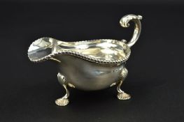 A GEORGE V SILVER SAUCE BOAT, gadrooned rim, 'S' scroll handle, on three cabriole legs with shell