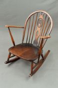 A DARK ERCOL WINDSOR ROCKING ARMCHAIR, (condition: varnish worn, mainly on armrests, frame solid)