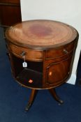 A REPRODUCTION MAHOGANY SWIVEL DRUM TABLE, with red tooled leather inlay top and three drawers,