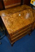 A REPRODUCTION WALNUT FALL FRONT BUREAU, with three drawers on cabriole legs