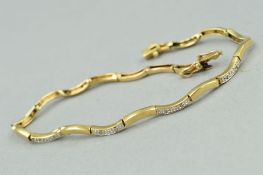 A 9CT GOLD DIAMOND BRACELET, designed as curved links, every other link set with two single cut